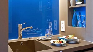 A modern kitchen with a stainless steel sink, a built-in wine cooler, and a breakfast bar with plates of food. - Seaside Residenz Hotel Chemnitz (Chemnitz)