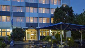 A hotel with a modern facade, outdoor seating area, and a visible entrance. - Seaside Residenz Hotel Chemnitz (Chemnitz)