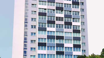 A multi-story building with a modern architectural design, featuring a series of balconies and large windows.