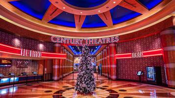 A spacious lobby with a Christmas tree, a cinema screen, and a 'Century Theatres' sign.