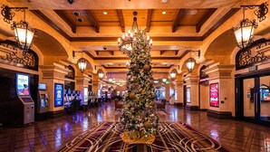Un vestíbulo con un árbol de Navidad, máquinas de juego y una señal de salida.