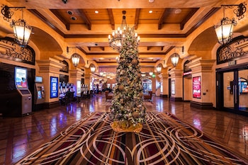 A modern bar area with a circular bar, multiple seating options, and a vibrant, colorful floor design. at Santa Fe Station Hotel & Casino
