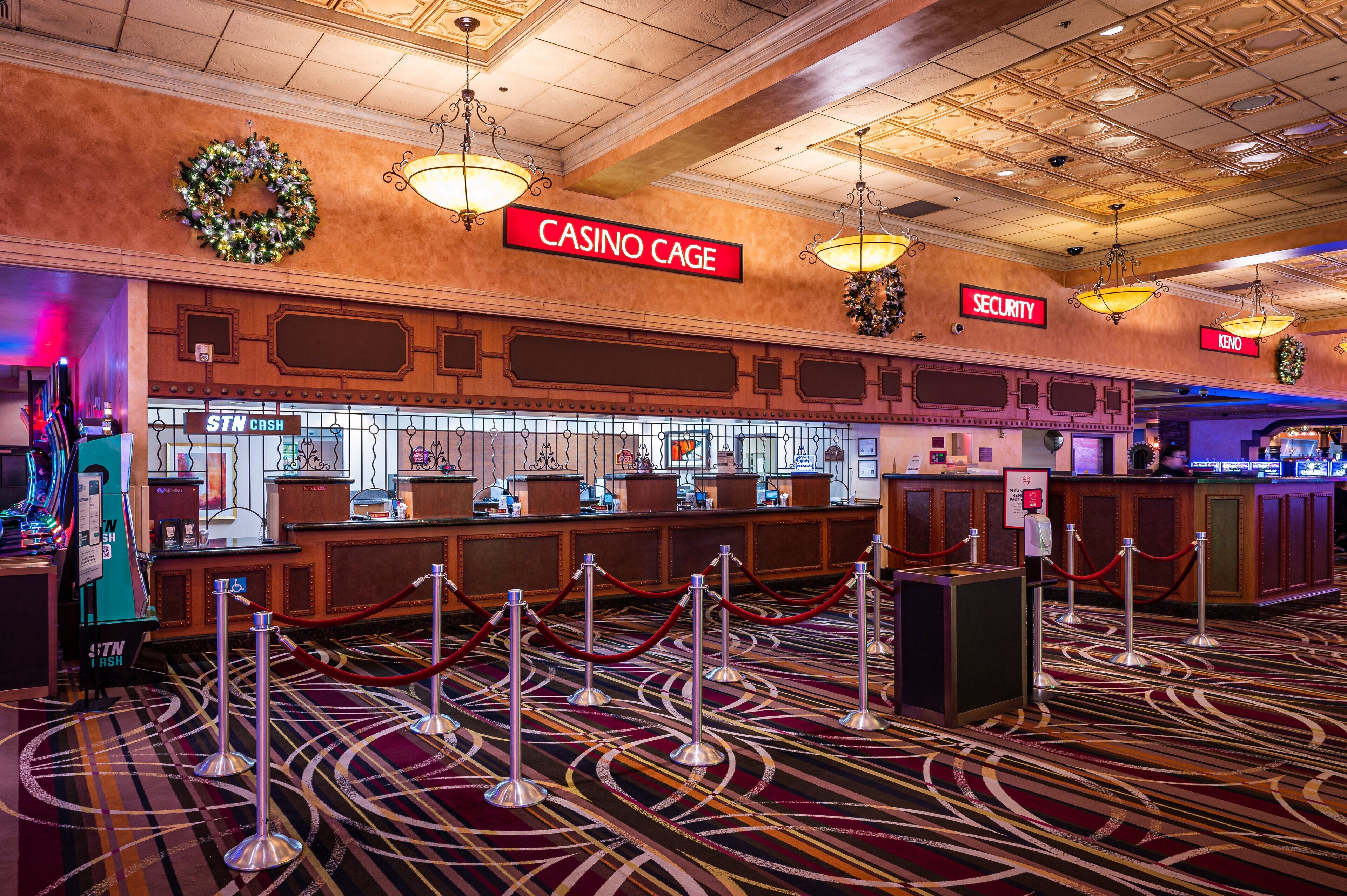 A casino cage area with a 'CASINO CAGE' sign, security sign, and 'STN CASH' counter.