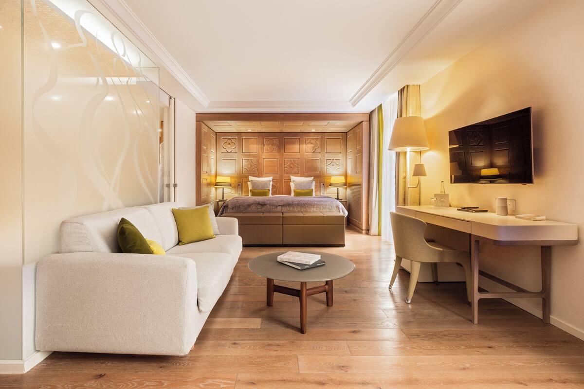Une chambre d’hôtel moderne équipée d’un canapé, d’un bureau, d’un lit et d’une télévision.