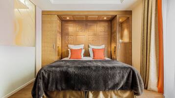 A bedroom with a large bed, wooden headboard, and a view of a cityscape.