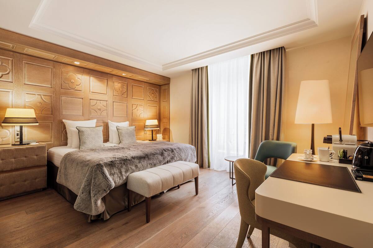 Une chambre d’hôtel avec un grand lit, un bureau, une chaise et un canapé.