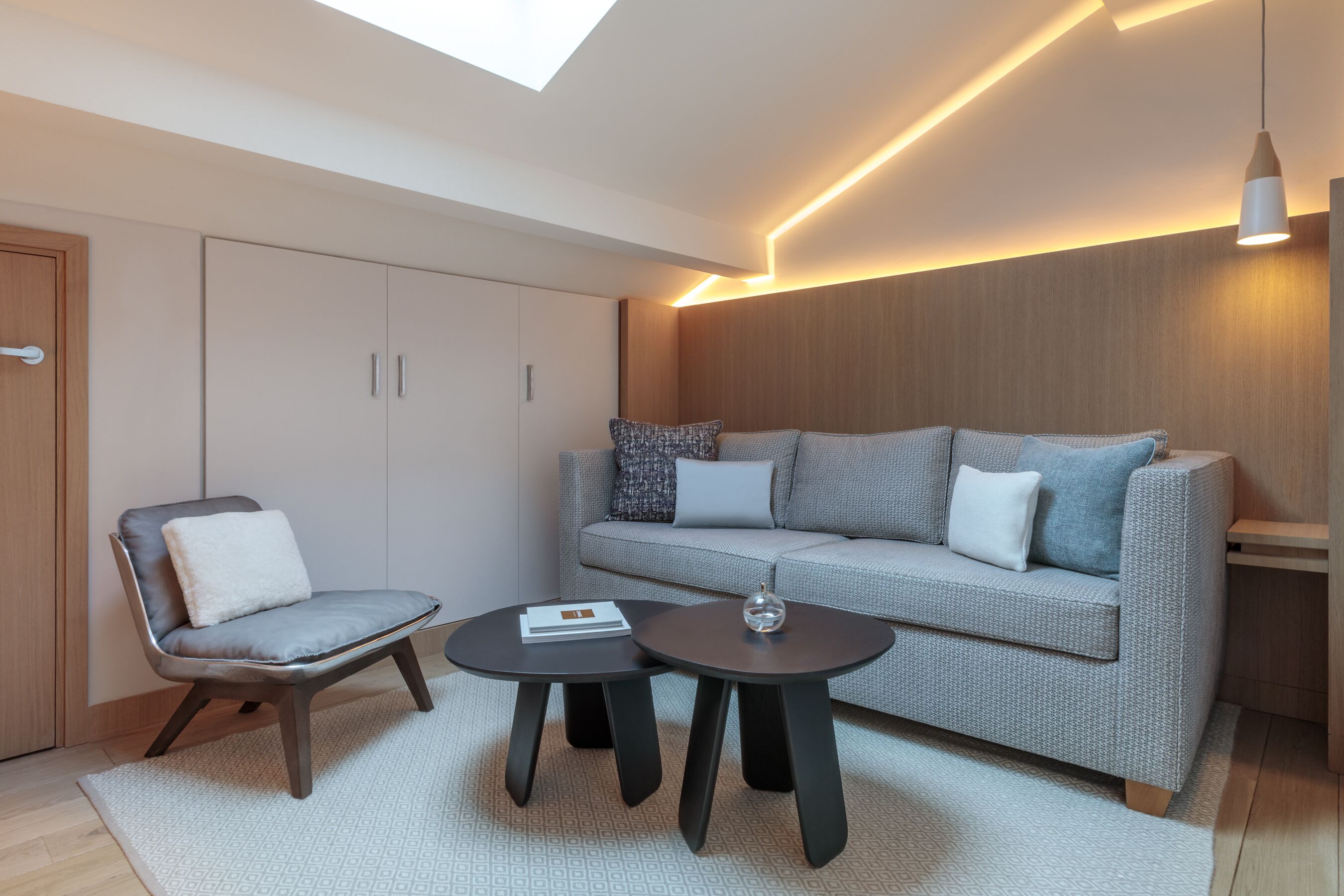 A modern living room with a sofa, two armchairs, and a coffee table.