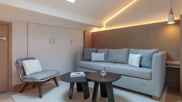 A modern living room with a sofa, two armchairs, and a coffee table.