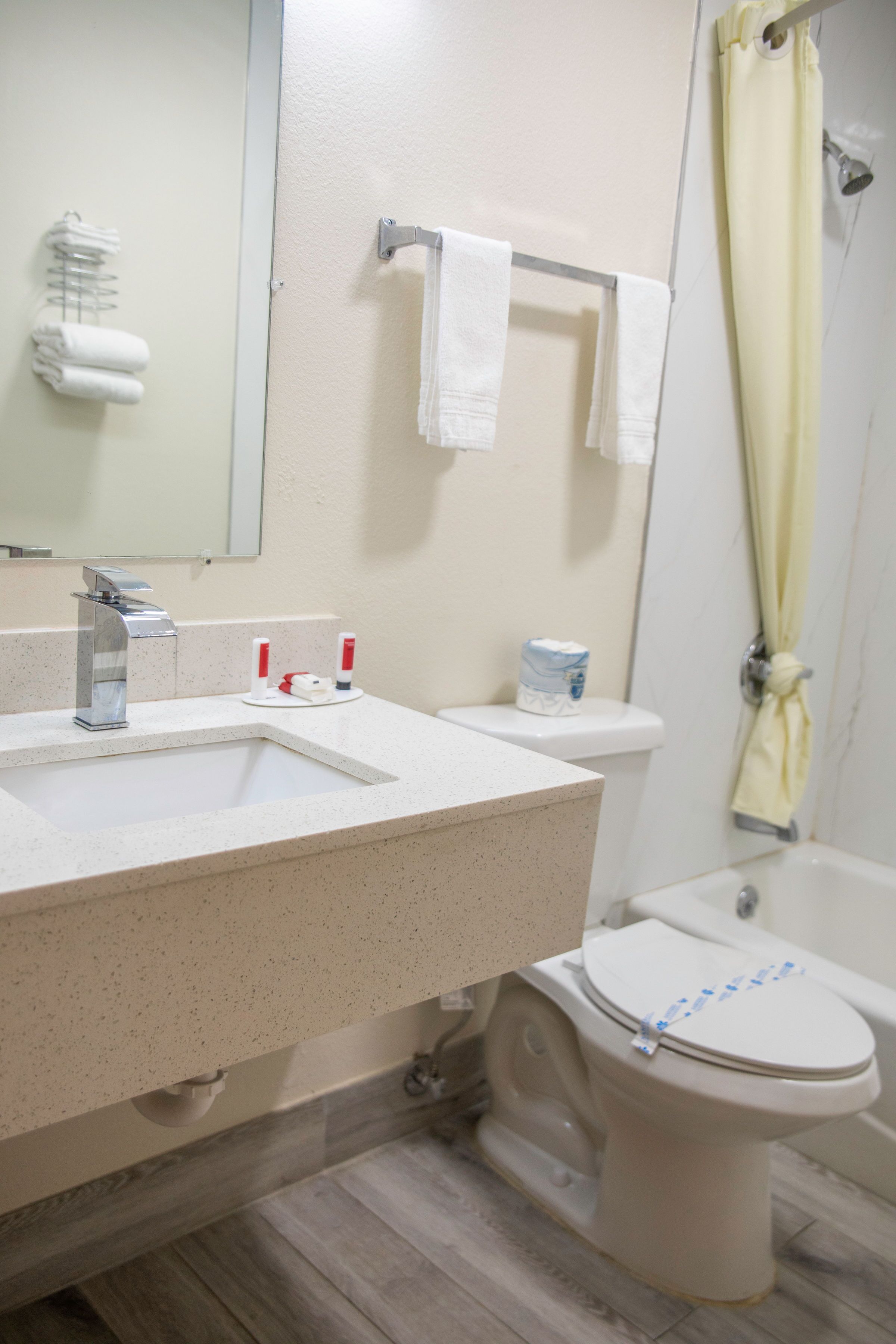 A bathroom with a sink, toilet, and shower curtain.
