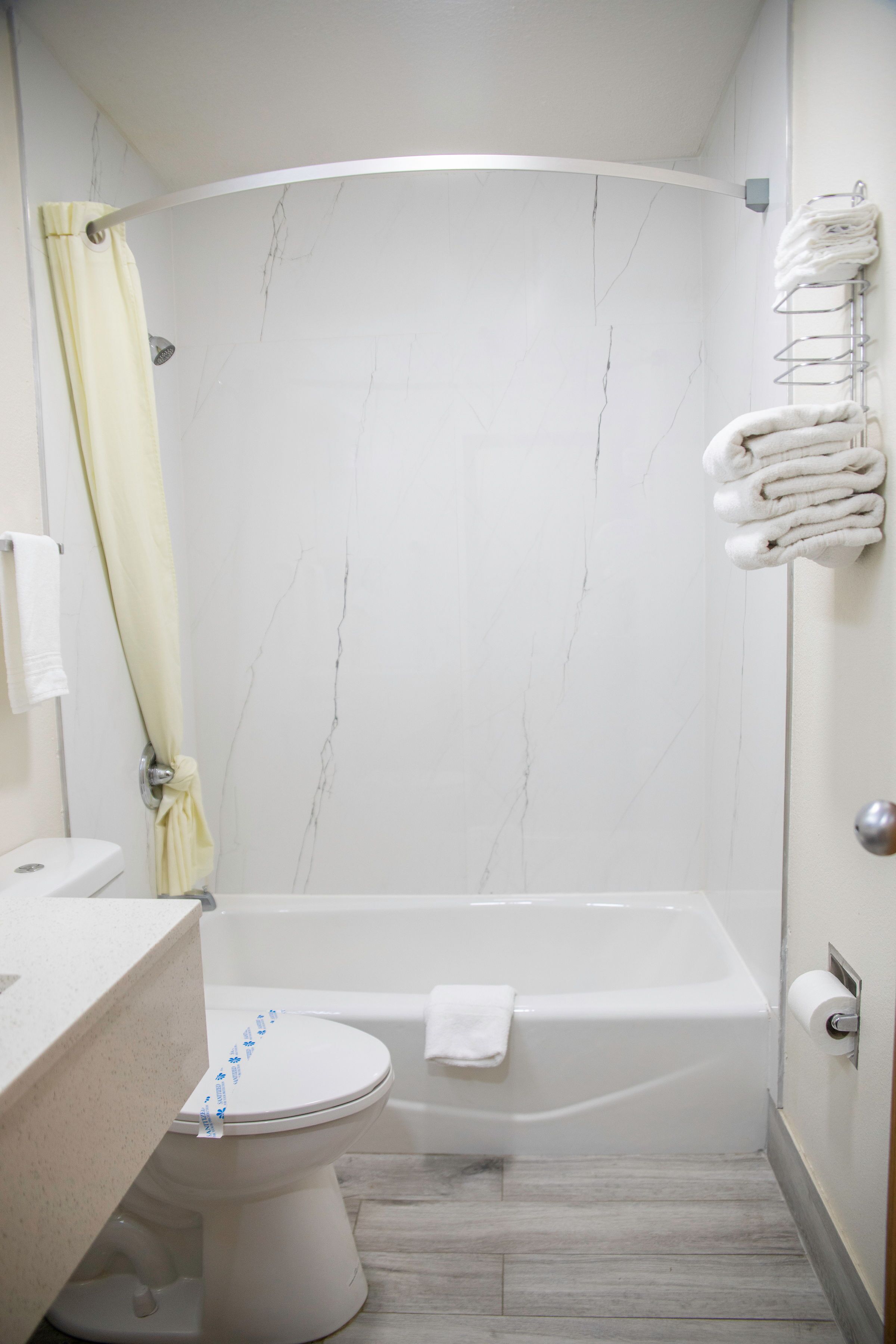 Un baño con inodoro, bañera y cortina de ducha.