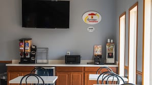 Un espace dédié au petit-déjeuner équipé d’un téléviseur à écran plat, de machines à café et d’un comptoir.