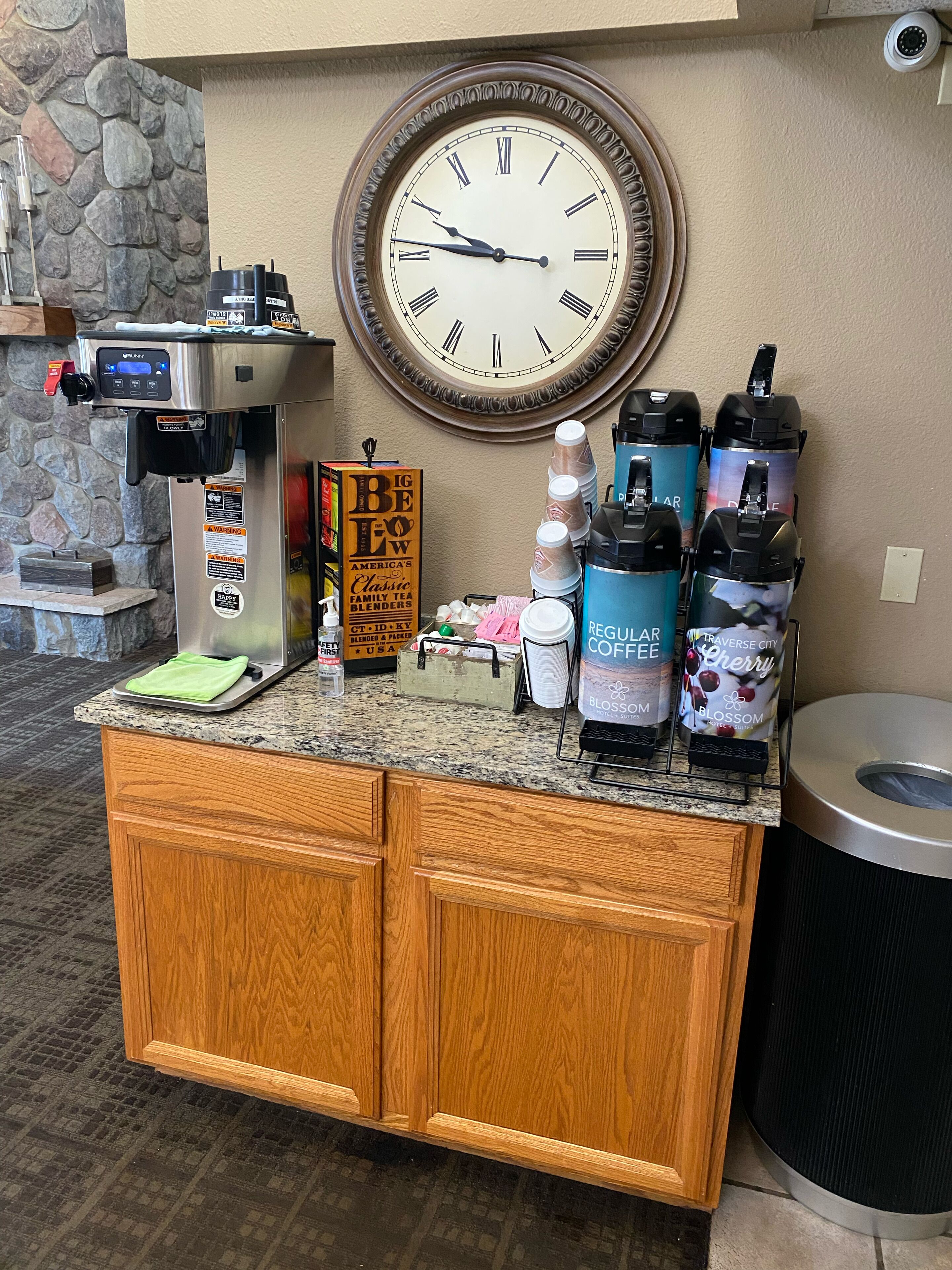 A coffee station with a coffee machine, a clock, and various coffee pods.