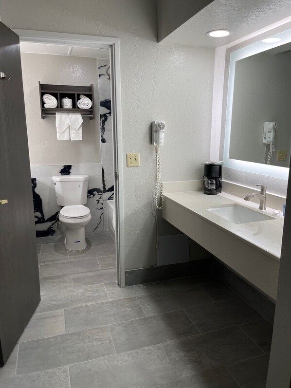 A modern bathroom with a toilet, sink, and hairdryer.