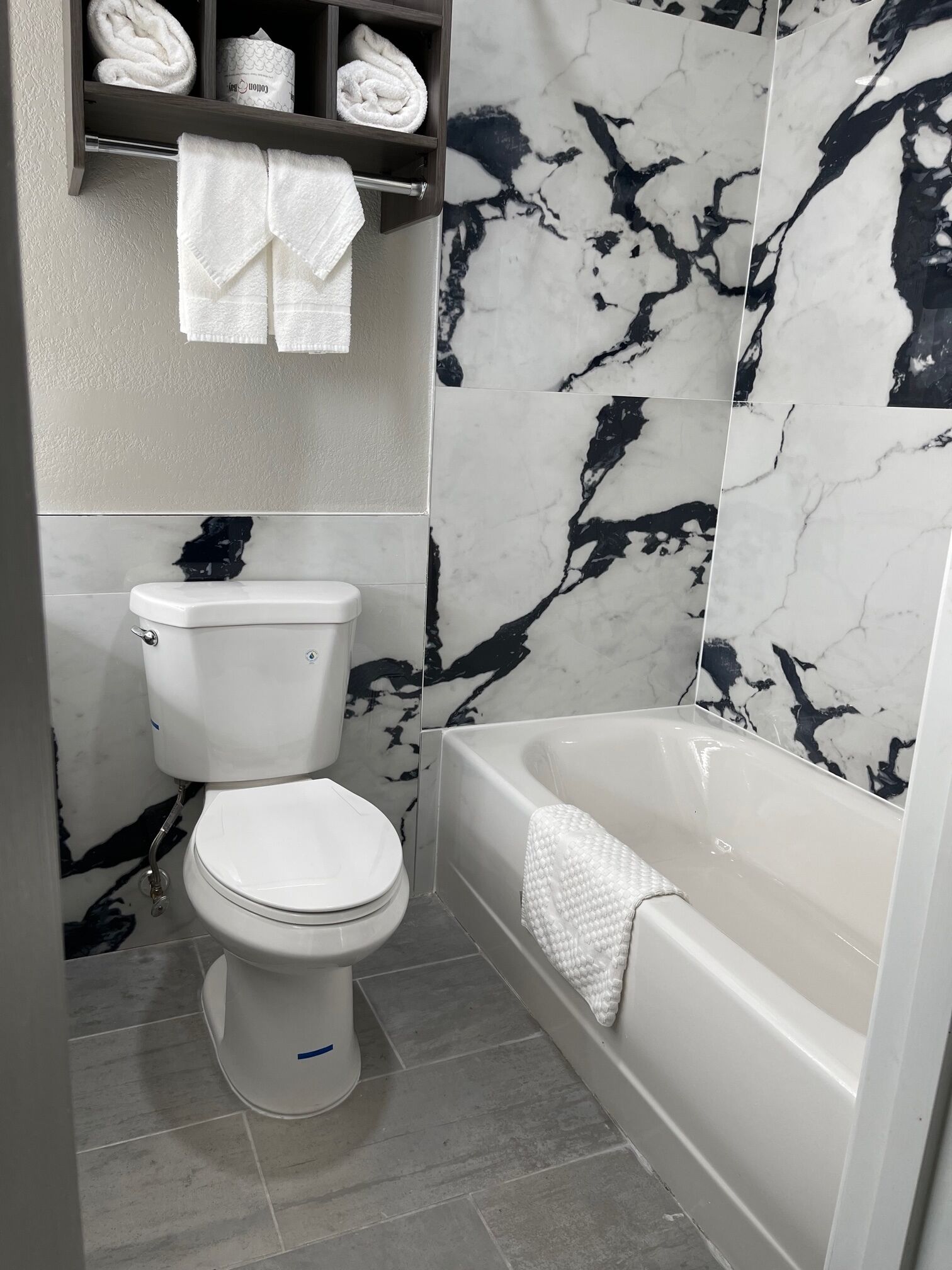 Un bagno con il water, una vasca da bagno e pareti in marmo.