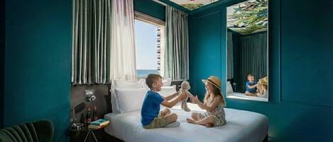 Una habitación con una cama, una ventana, cortinas, una lámpara y una silla.