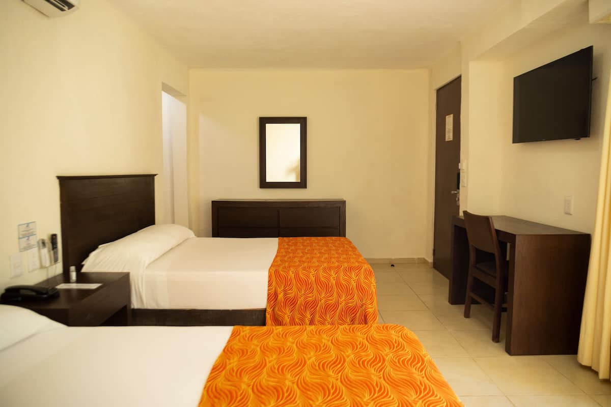 A hotel room with two beds, a desk, a chair, a TV, and a mirror.