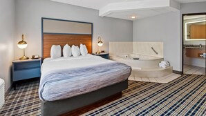Habitación de hotel con una cama grande, baño independiente con bañera y diseño moderno.