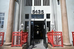 A building entrance with the number 5435, a sign indicating an office, and red railings.