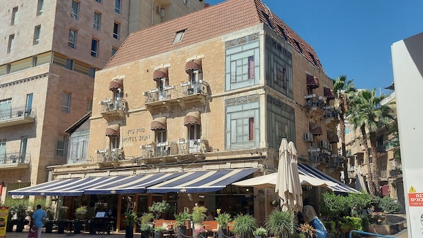 A hotel with a traditional facade, outdoor seating, and a clear blue sky. - Zion Hotel (Jerusalem)