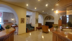 A spacious living area with a fireplace, comfortable seating, and a television. - Zion Hotel (Jerusalem)