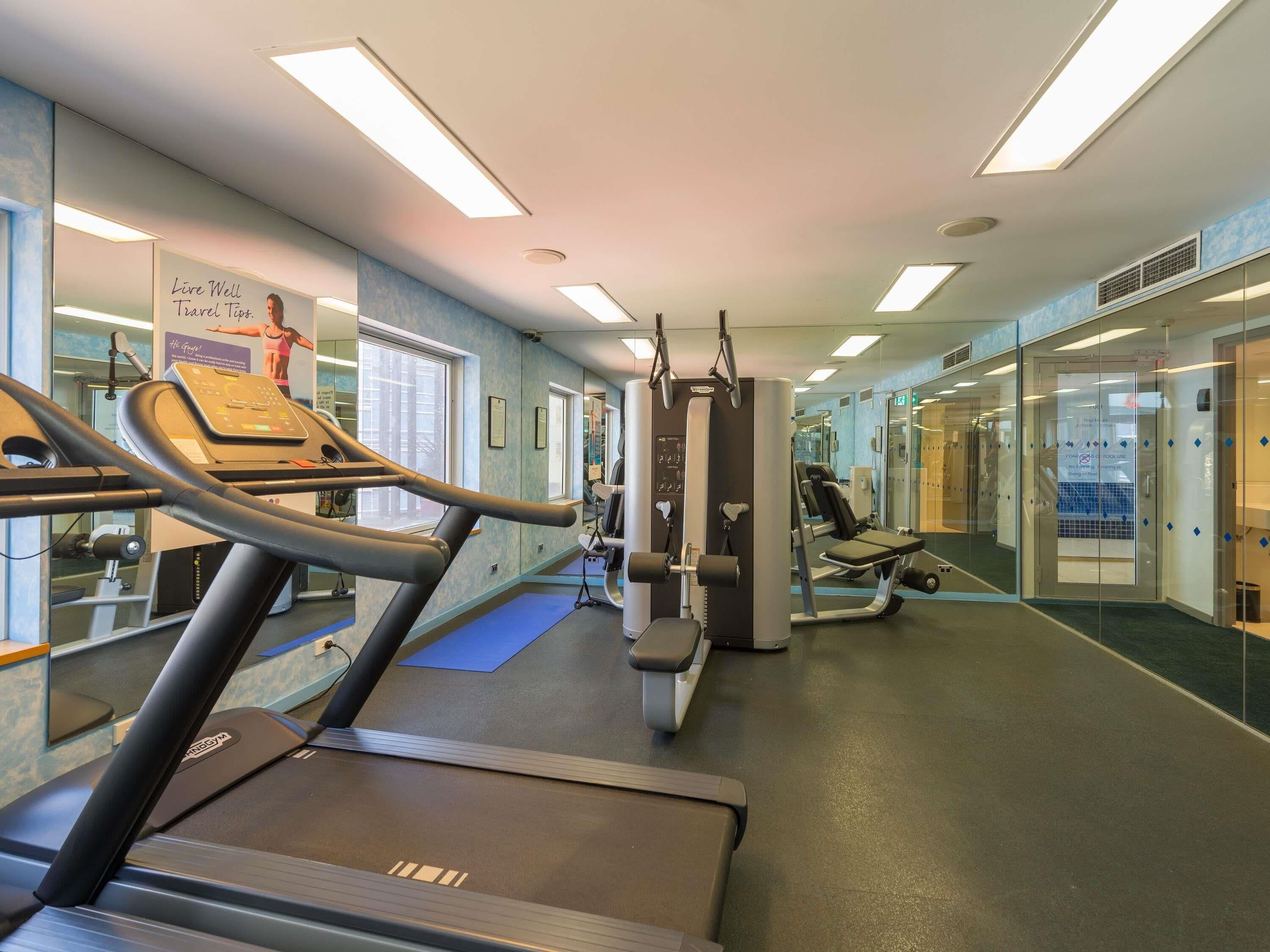A gym with treadmills, weight machines, and exercise mats.
