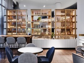 Un área de bar moderna con asientos y exhibiciones de cristalería.
