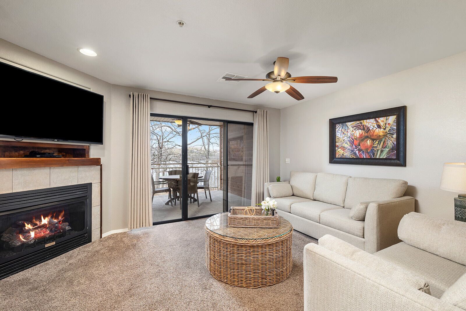 A living room with a fireplace, a sofa, a coffee table, and a ceiling fan.
