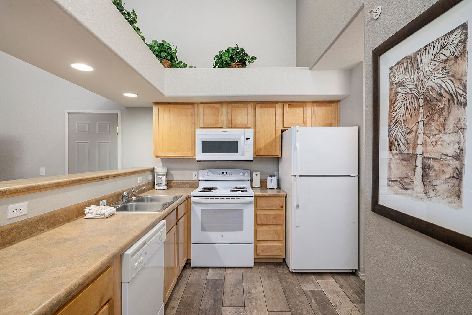 A modern kitchen with wooden cabinets, a microwave, a refrigerator, and a dishwasher.
