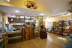 A coffee shop interior with a wooden counter, coffee machines, and shelves stocked with various coffee products.