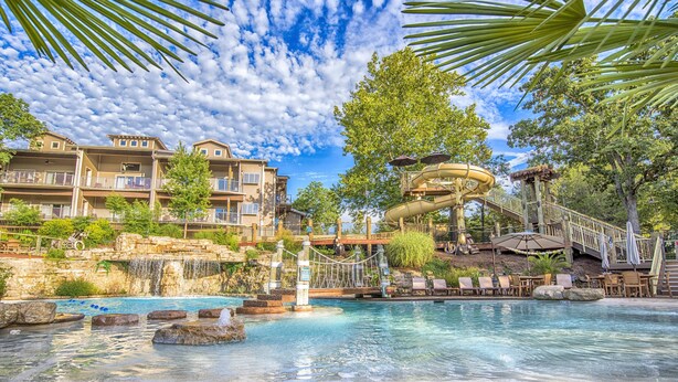 A resort with a pool, water slides, and a bridge. - Still Waters Resort (Branson)