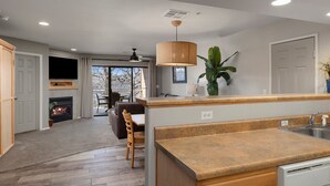 A modern kitchen with a wooden countertop, a built-in oven, and a dining area with a table and chairs. - Still Waters Resort (Branson)