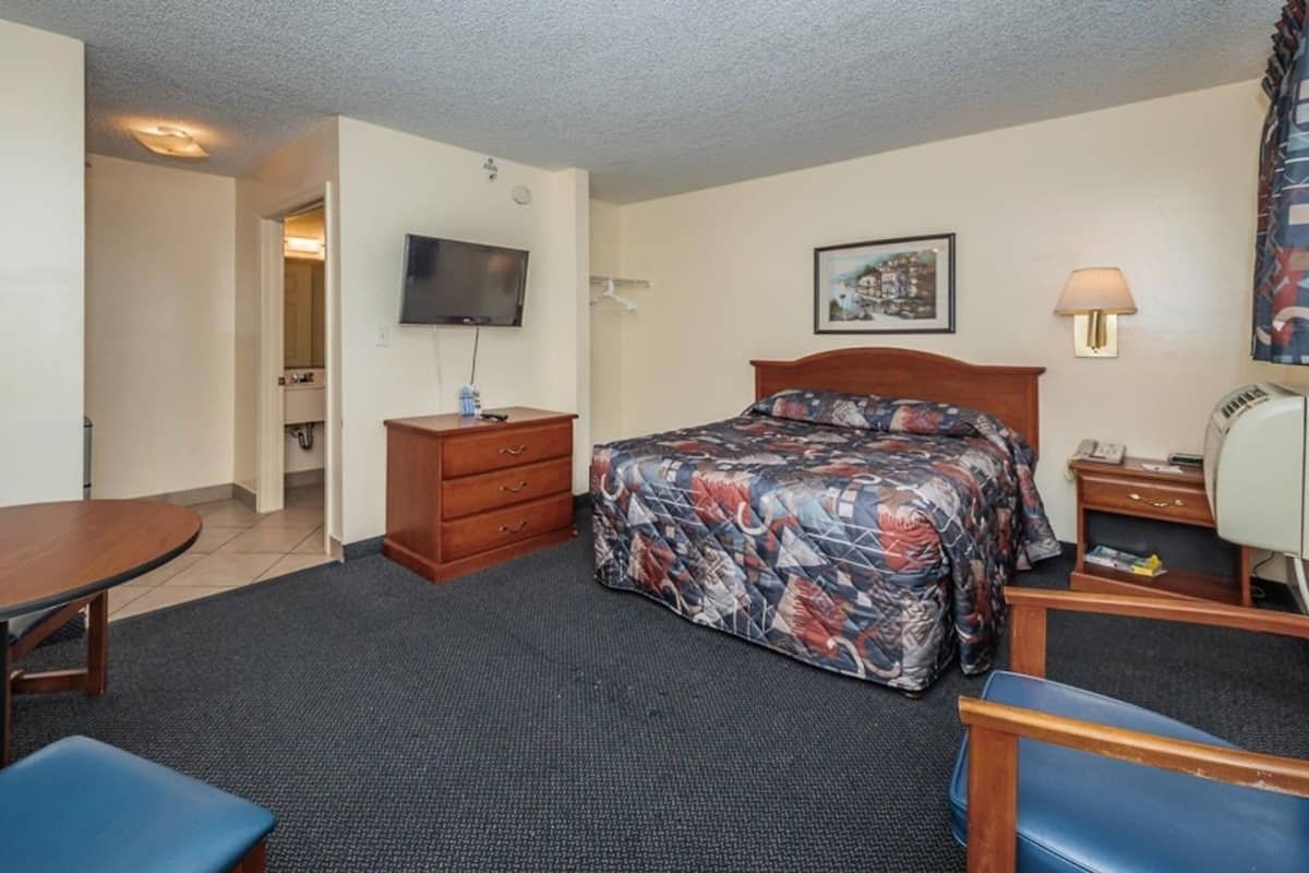 Une chambre d’hôtel comprenant un lit, une télévision, un bureau, une chaise et une table.