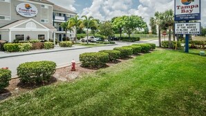 A Tampa Bay Extended Stay Hotel with a parking lot, a fire hydrant, and a stop sign.
