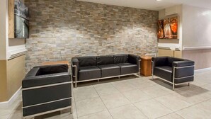 Ein modernes Wohnzimmer mit einem Ecksofa, einem Couchtisch und einer Wand mit Steinverkleidung.