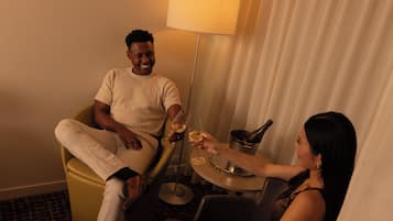 Una habitación de hotel con una cama, una mesita de noche y una lámpara.