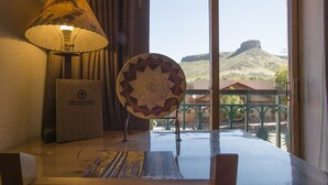 Una mesa con una lámpara, un plato decorativo y un cartel que dice "Table Mountain Inn".