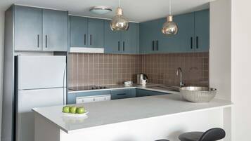 Una cocina moderna con una isla central, electrodomésticos de acero inoxidable y armarios azules.