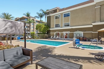 Outdoor pool, open 7 AM to 10 PM, pool umbrellas, sun loungers at Anaheim Portofino Inn and Suites