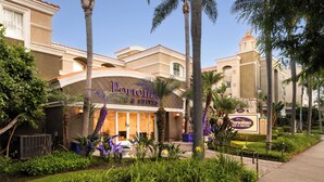 A hotel with a prominent sign reading "Portofino Inn & Suites" and a classic Mediterranean architectural style. - Anaheim Portofino Inn and Suites (Anaheim)