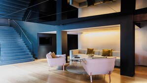 A modern living room with a staircase, a sofa set, and a coffee table. - The Prince (St Kilda)