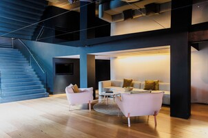 A modern living room with a staircase, a sofa set, and a coffee table.