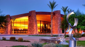 A modern building with a curved facade, large windows, and a central entrance. - Desert Lodge (Palm Springs)