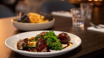 A plate of food with meatballs and broccoli on a table.