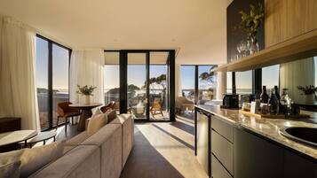Cocina moderna con una isla grande, zona de comedor con sofá y vistas al exterior.