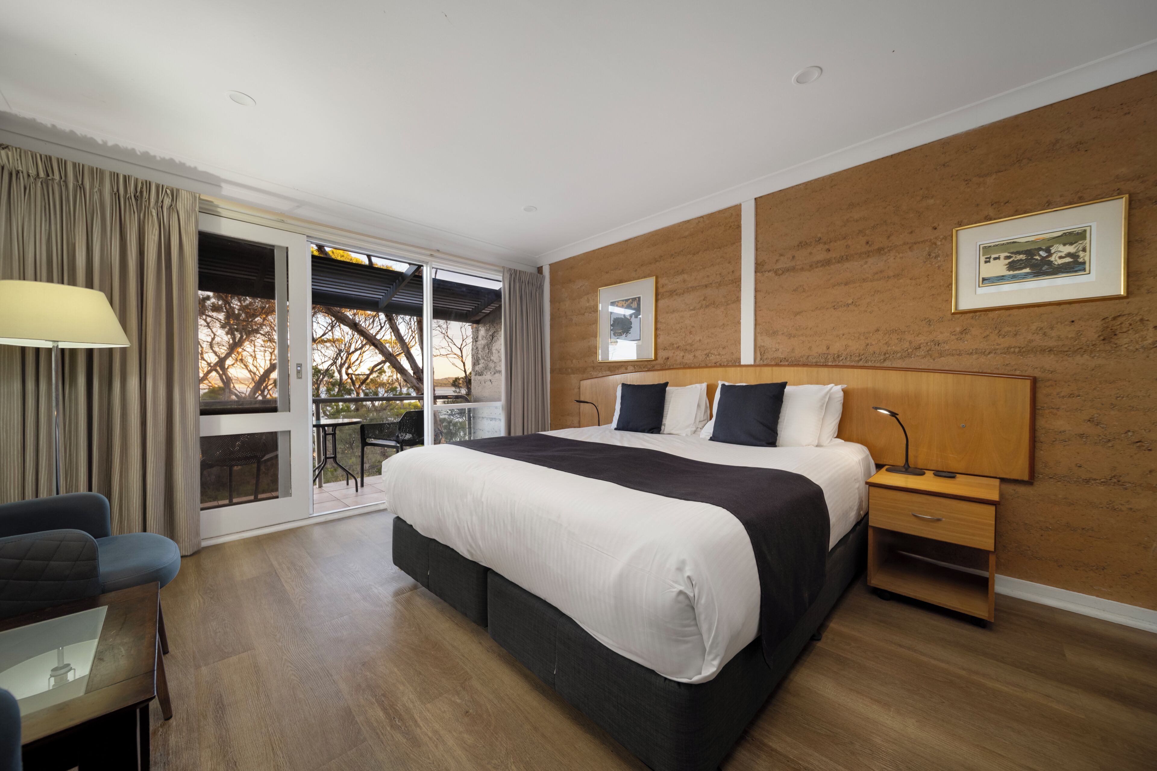 Una moderna camera d'hotel con un ampio letto, una scrivania, una sedia e vista sull'esterno.