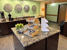Un banco della colazione con diversi cibi e una macchina per caffè.