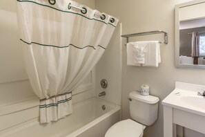 A bathroom with a bathtub, toilet, and sink.