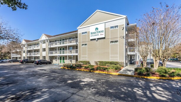 A multi-story building with a sign for 'Home Towne Studios by Red Roof.' - HomeTowne Studios by Red Roof Orlando - Casselberry (Casselberry)