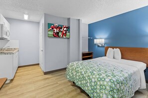 A hotel room with a bed, a television, a desk, and a microwave.