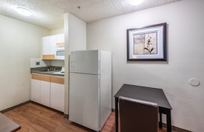 Een koelkast met diepvriezer, een microgolfoven, een kookplaat